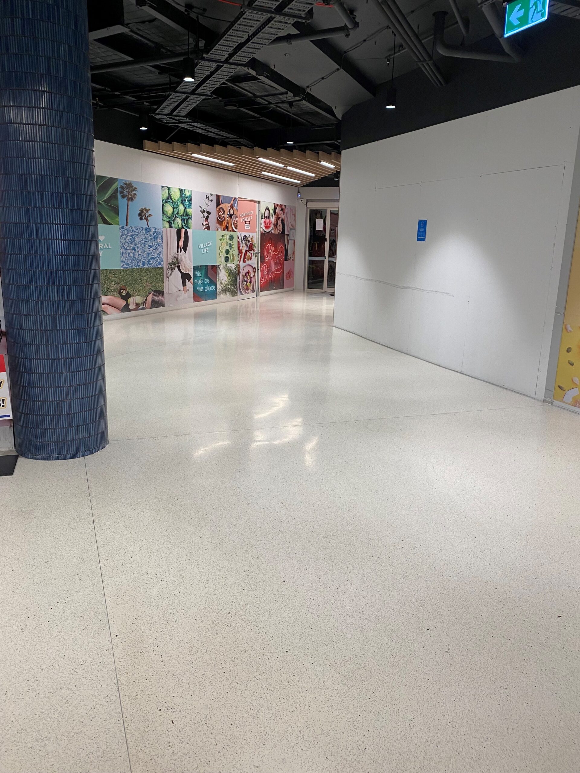 Polished terrazzo-style flooring in a busy retail centre corridor