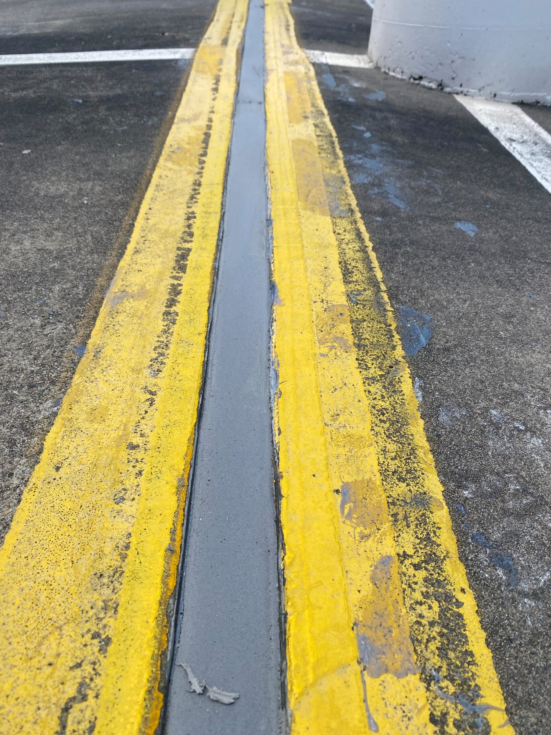 Freshly resealed expansion joint in a line-marked car park